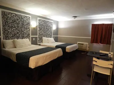 a hotel room with two beds and a desk at Hotel Salina in Long Beach