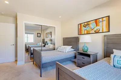a bedroom with two beds and a mirror at Castles Reach in Anaheim