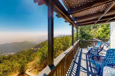a balcony with blue chairs and a view of mountains at Million Dollar Mountain View in Crestline