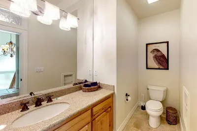 a bathroom with a sink and a toilet and a mirror at Bayfront Beauty in Lake Arrowhead