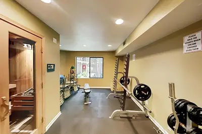 a gym with treadmills and machines in a room at Pacific Cove Unit 111 in Los Angeles