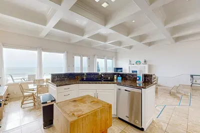a large kitchen with a table and some chairs at Breakers Way Dream in Carpinteria
