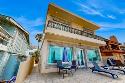 a house with a patio with chairs and a table at Breakers Way Dream in Carpinteria