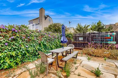 a patio with a table and chairs and an umbrella at Sailaway Cabin A in Ventura