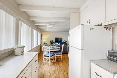 a kitchen with a white refrigerator and a table with chairs at Sailaway Cabin A in Ventura