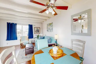 a living room with a table and a ceiling fan at Sailaway Cabin B in Ventura
