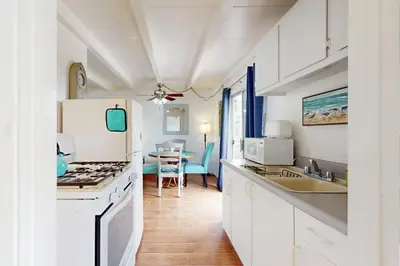 a kitchen with white cabinets and a white refrigerator at Sailaway Cabin in Ventura