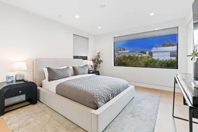 a white bedroom with a bed and a large window at Curson Modern in Los Angeles