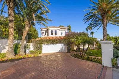 a house with palm trees and a driveway at Stradella Spanish in Los Angeles