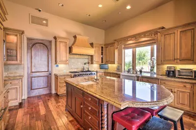 a large kitchen with wooden cabinets and a large island at Stunning Palmdale Villa Oasis on Vineyard! in Palmdale