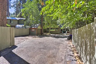 a backyard with a fence and a driveway at Cozy Skyforest Cabin about 1 Mi to Lake Arrowhead! in Skyforest