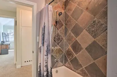 a bathroom with a shower with a tiled wall at Cozy Skyforest Cabin about 1 Mi to Lake Arrowhead! in Skyforest