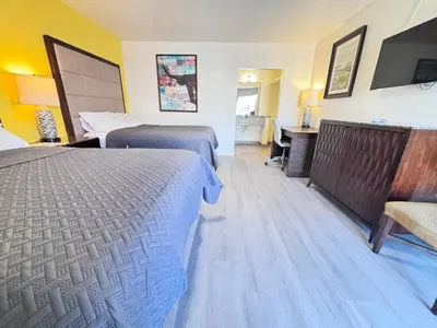 a hotel room with two beds and a desk at The Crest Motel in Corona