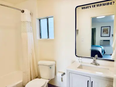 a bathroom with a toilet and a sink and a mirror at The Crest Motel in Corona