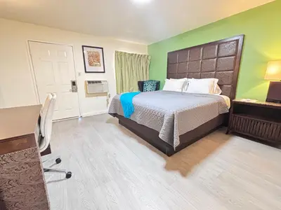 a bedroom with a bed and a desk with a chair at The Crest Motel in Corona
