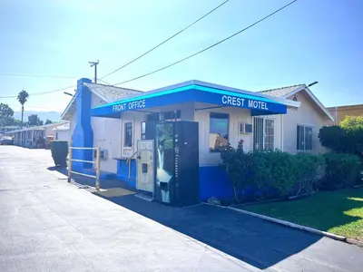 a small blue and white house with a guest motel at The Crest Motel in Corona