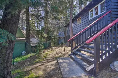 a staircase leading to a house with a tree at Newly Renovated Lake Arrowhead Cabin with Deck! in Lake Arrowhead
