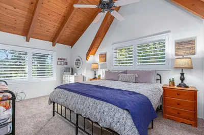 a bedroom with a bed and a ceiling fan at Serene Cabin in Lake Arrowhead