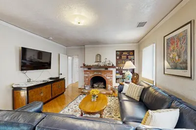 a living room with a leather couch and a fireplace at Cedar Oasis in Ventura