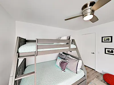 a bunk bed room with two bunk beds and a ceiling fan at Hale I'a in Carpinteria