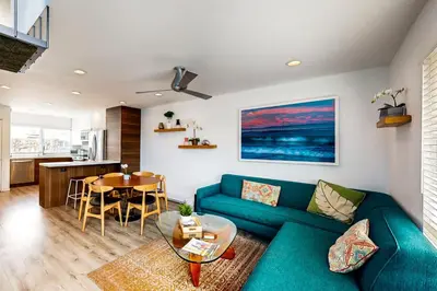 a living room with a blue couch and a table at Hale I'a in Carpinteria