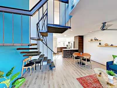 a living room with a staircase and a dining room at Hale I'a in Carpinteria