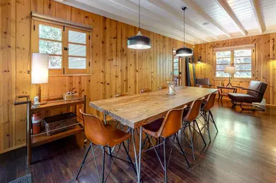 a dining room with a large wooden table and chairs at Hideaway Pines in Lake Arrowhead