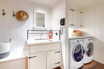 a white laundry room with a washer and dryer at Hideaway Pines in Lake Arrowhead