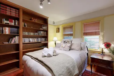 a bedroom with a large bed with book shelves at Highland Park Haven in Los Angeles