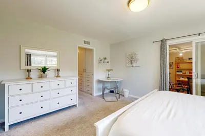 a bedroom with a white bed and a table at Evening Oasis in Orange