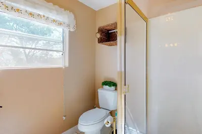 a bathroom with a toilet and a window and a shower at Tree-Top Getaway in Lake Arrowhead