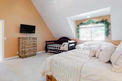 a bedroom with a large bed and a television at Tree-Top Getaway in Lake Arrowhead