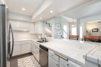 a kitchen with white cabinets and a sink at Sunset Palace in Hermosa Beach