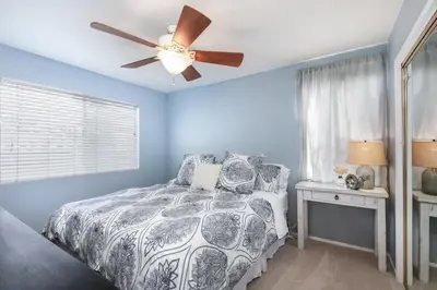 a blue bedroom with a bed and a ceiling fan at Sunset Palace in Hermosa Beach