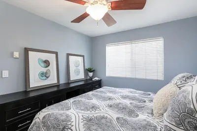 a bedroom with a bed and a ceiling fan at Sunset Palace in Hermosa Beach