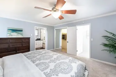 a bedroom with a ceiling fan and a bed at Sunset Palace in Hermosa Beach
