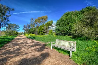 a wooden bench sitting on the side of a dirt road at Sunset Palace in Hermosa Beach