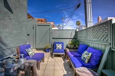 a patio with blue couches and pillows at Sunset Palace in Hermosa Beach