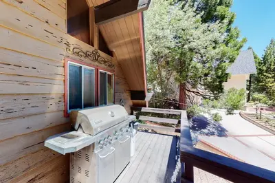 a wooden cabin with a stove on a deck at Annandale Manor in Lake Arrowhead