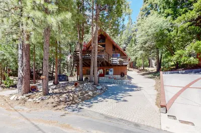 a log home in the woods with a driveway at Annandale Manor in Lake Arrowhead