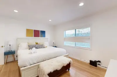 a white bedroom with a bed and a window at Tullis Charm in Los Angeles