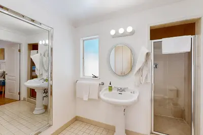 a white bathroom with a sink and a mirror at Tullis Charm in Los Angeles