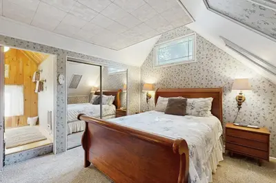 a bedroom with a large bed and a mirror at The Cottage in Lake Arrowhead