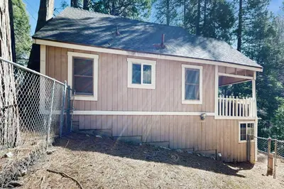a small house with a fence in a yard at The Cottage in Lake Arrowhead