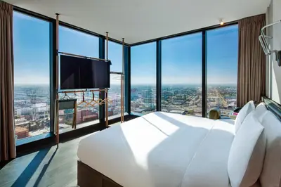 a bedroom with a large white bed and large windows at Moxy Downtown Los Angeles in Los Angeles
