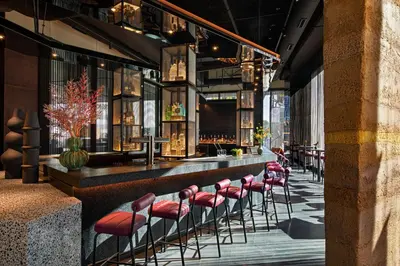 a bar with a row of red stools at Moxy Downtown Los Angeles in Los Angeles