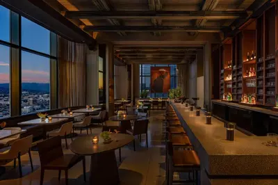 a restaurant with tables and chairs and a large window at Moxy Downtown Los Angeles in Los Angeles