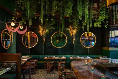 a restaurant with tables and mirrors on the wall at Moxy Downtown Los Angeles in Los Angeles