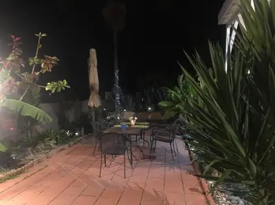 a patio with a table and chairs and an umbrella at Cozy beach home walking distance from ocean in Ventura