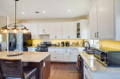 a kitchen with white cabinets and a large island at Lake Arrowhead Getaway with Decks and Game Room! in Lake Arrowhead